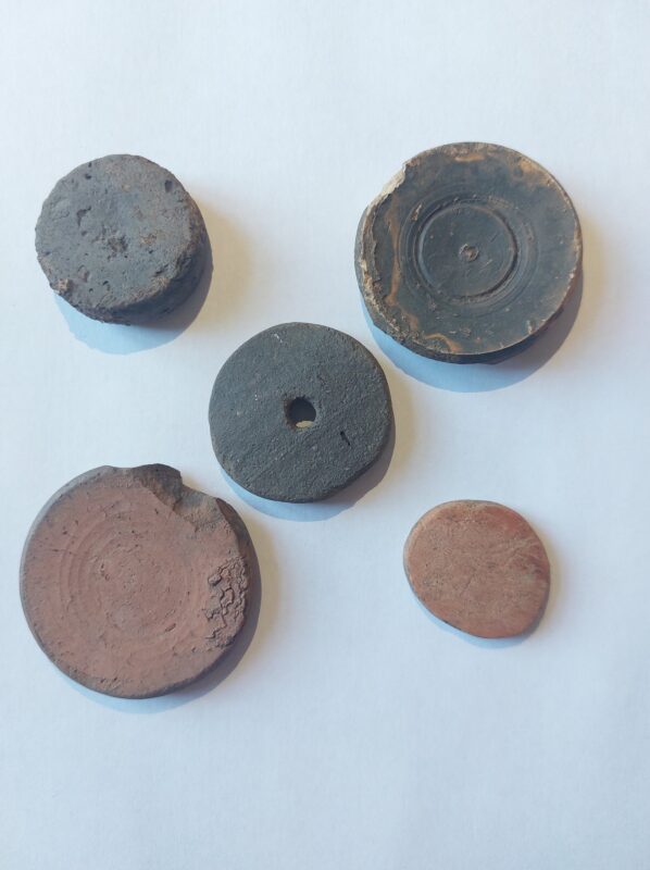A collection of five pot counters, one with a hole in the middle