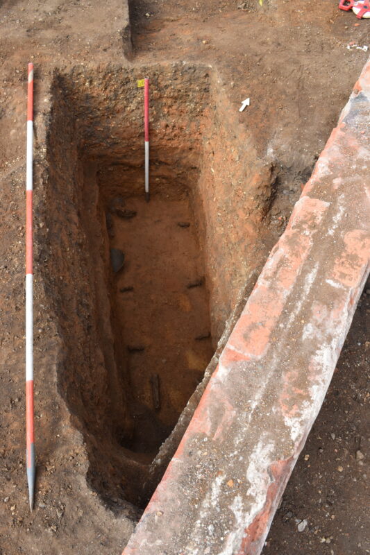 Coffin nails seen at the base of a grave, showing the outline of the coffin