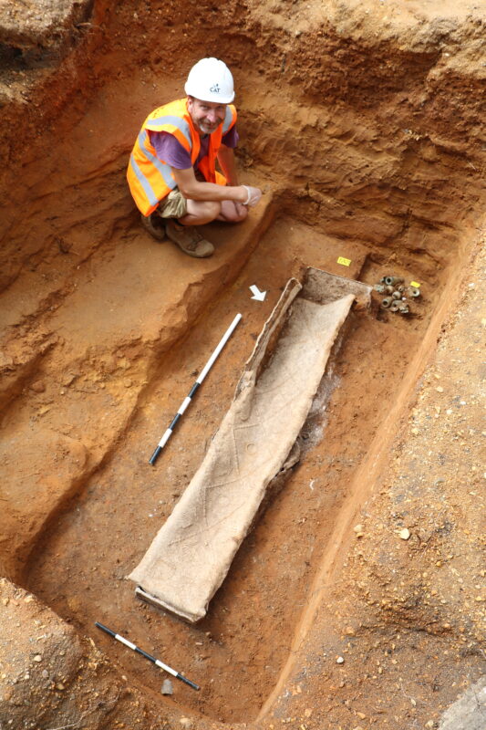 Image shows an archaeologist on site with the lead coffin prior to the lid being lifted