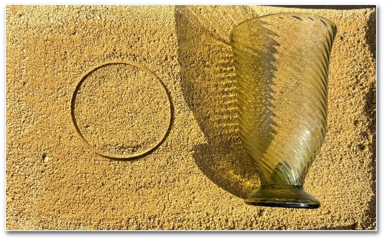 Image of a glass vessel and the corresponding indentation in sand